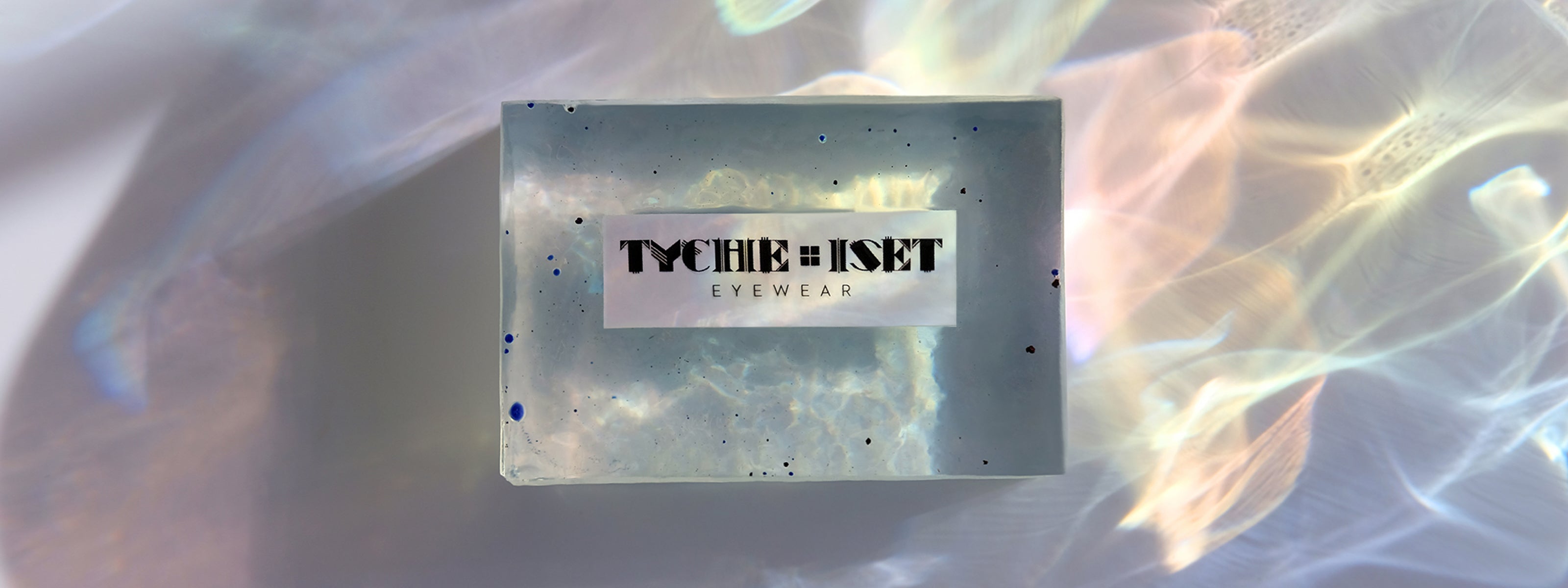 Rectangular product packaging with 'Tyche & Set' branding on a gradient background.