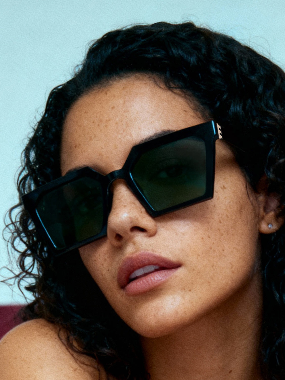 close-up portrait of woman wearing black square sunglasses with olive green AR coated lenses, gold metal details, premium eyewear, unisex sunglasses