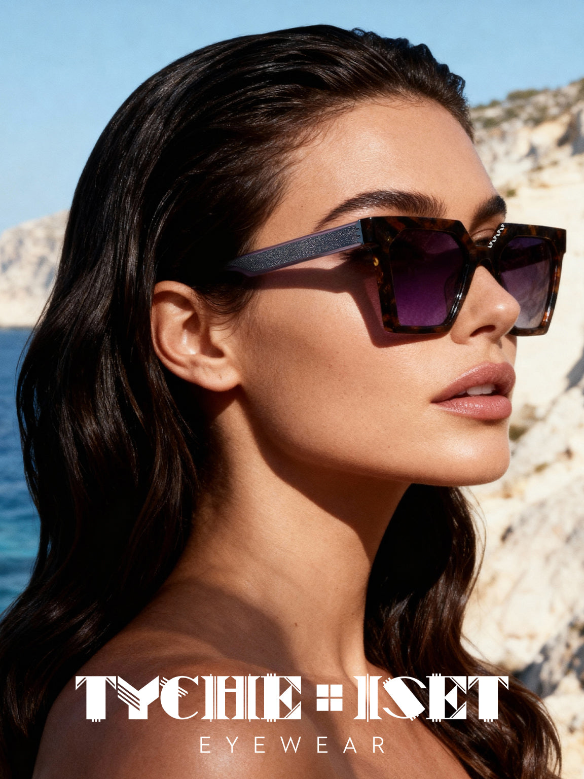 woman wearing brown and silver squared framed glasses overlooking the ocean and cliffside in nature